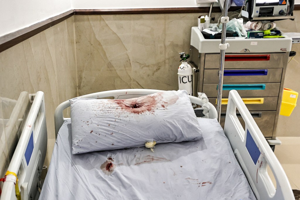 A bullet hole is pictured on a pillow covered in blood on a hospital bed at the Ibn Sina hospital in Jenin in the occupied West Bank