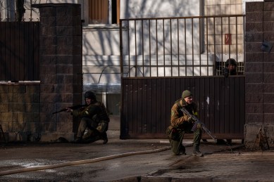 Ukrainian soldiers take positions outside a military facility after an explosion in Kyiv, Ukraine, Saturday, Feb. 26, 2022.