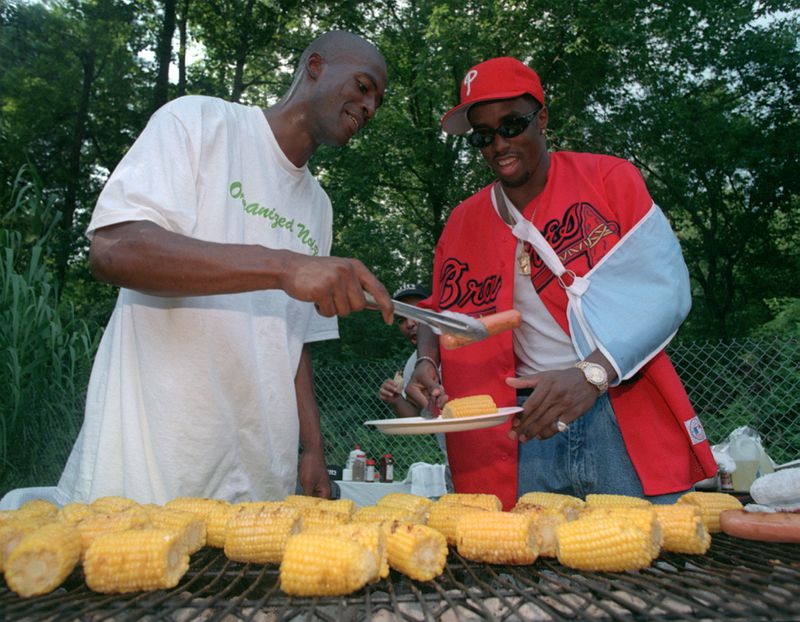 Rico Wade, left, serves up some barbeque to rap star Sean Puffy Combs during a party at Wade's house on Sunday, Aug. 17, 1997. (AJC Staff Photo/Mark Adams)
