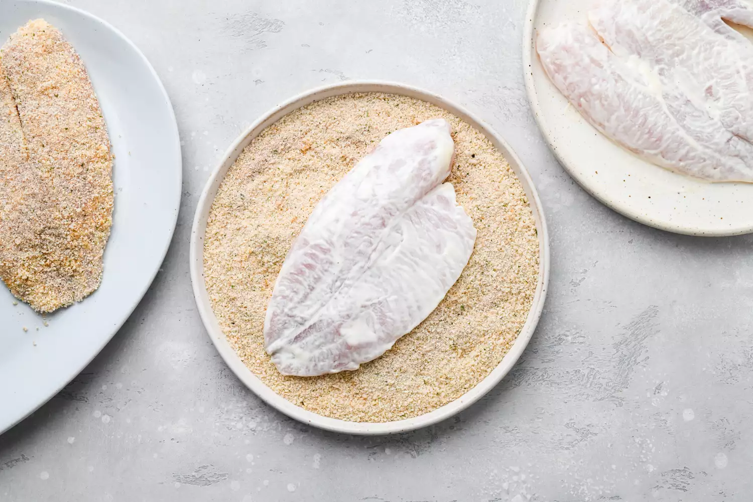 Tilapia dipped in bread crumb mixture on a plate