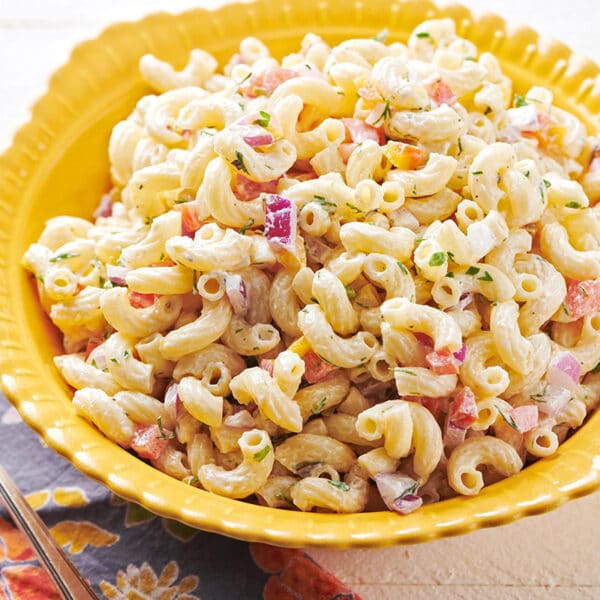 Old-fashioned macaroni salad in yellow bowl on table.
