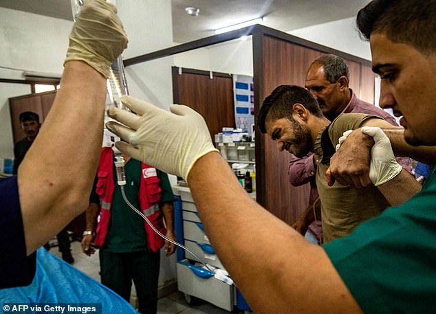 People who were injured during the ongoing Turkish offensive against Kurdish-controlled areas of northeastern Syria receive treatment at a hospital in Tal Tamr