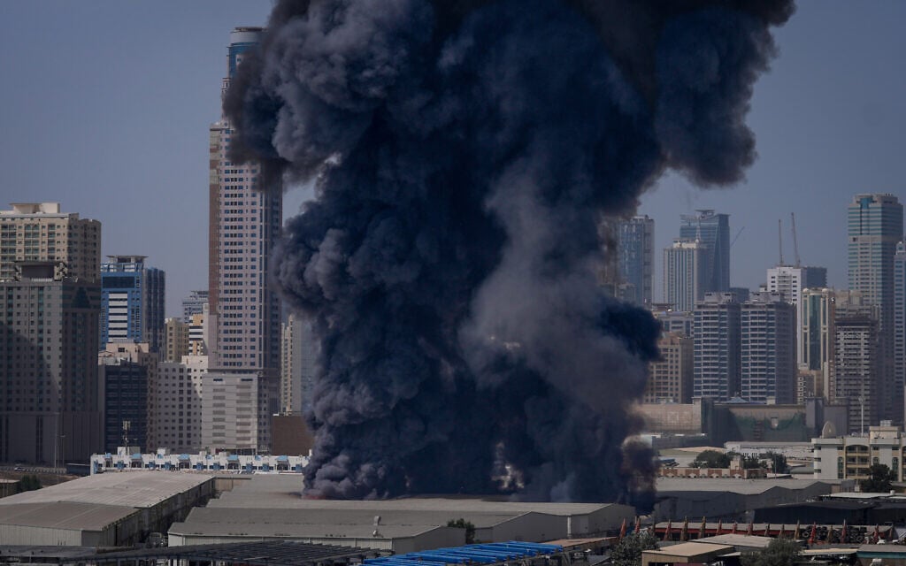 A black plume of smoke rises from a warehouse at the industrial area of Sharjah City in the United Arab Emirates following reports of Iranian strikes in Dubai, United Arab Emirates, March 1, 2026. (AP Photo/Altaf Qadri)