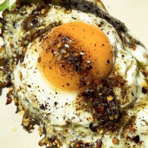One fried egg on toast with chili crisp oil drizzled on top.