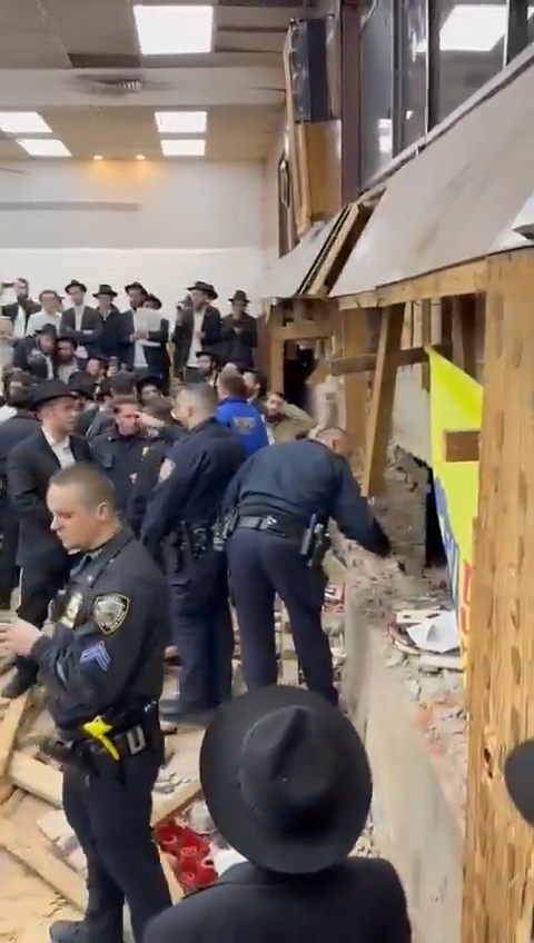 A cop is pictured reaching inside the tunnel.