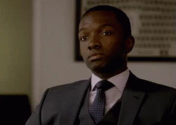 a man in a suit and tie is looking at the camera and making a funny face .