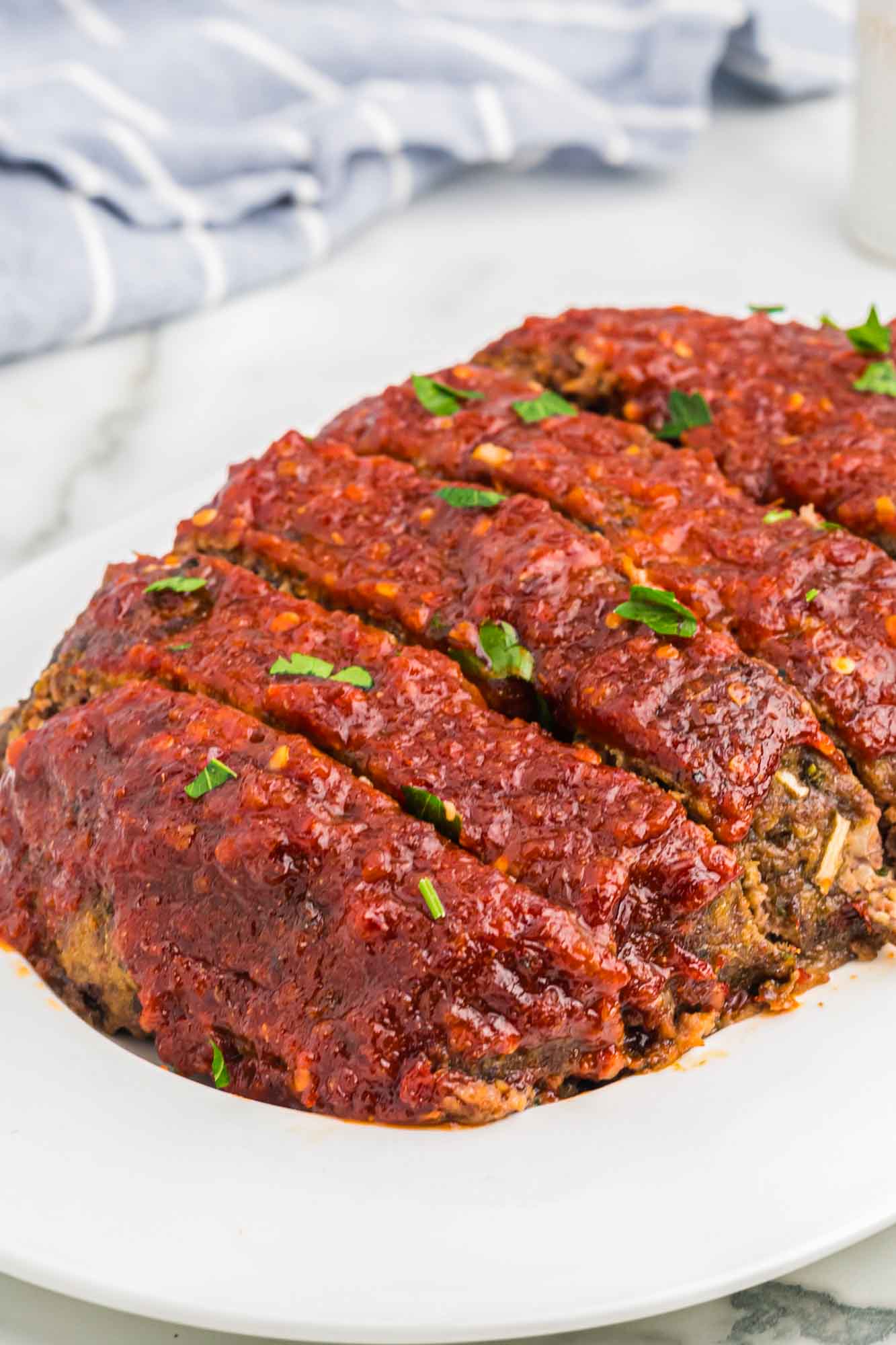 Whole glazed beef meatloaf served on a white platter
