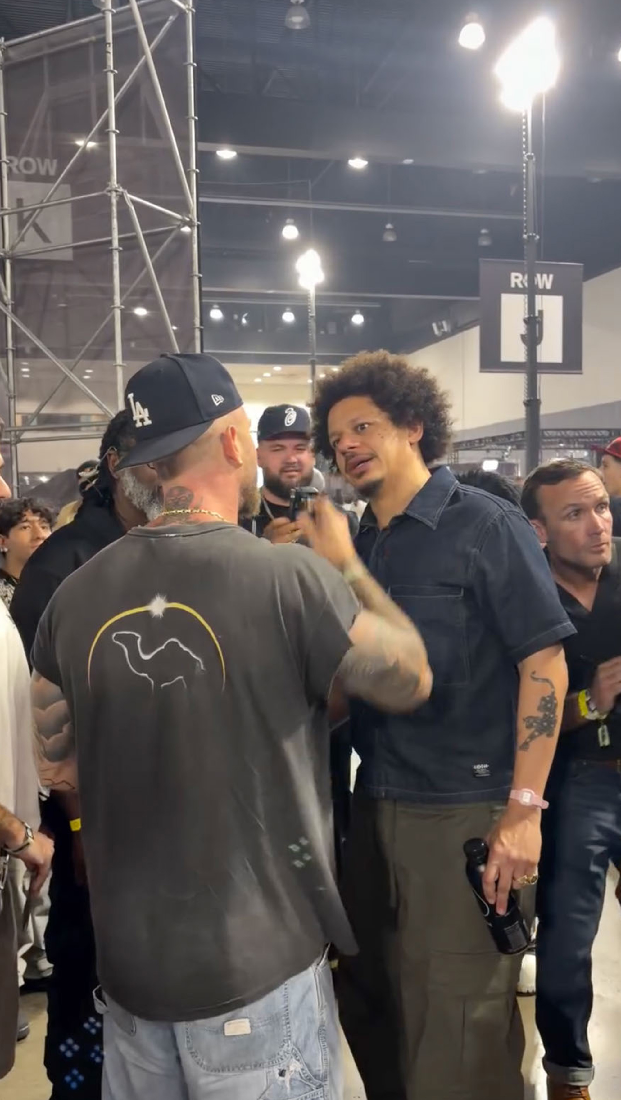 Chet Hanks and Eric Andre standing together in a crowded room.