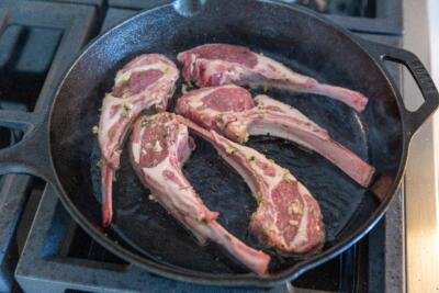 lamb chops frying in a pan