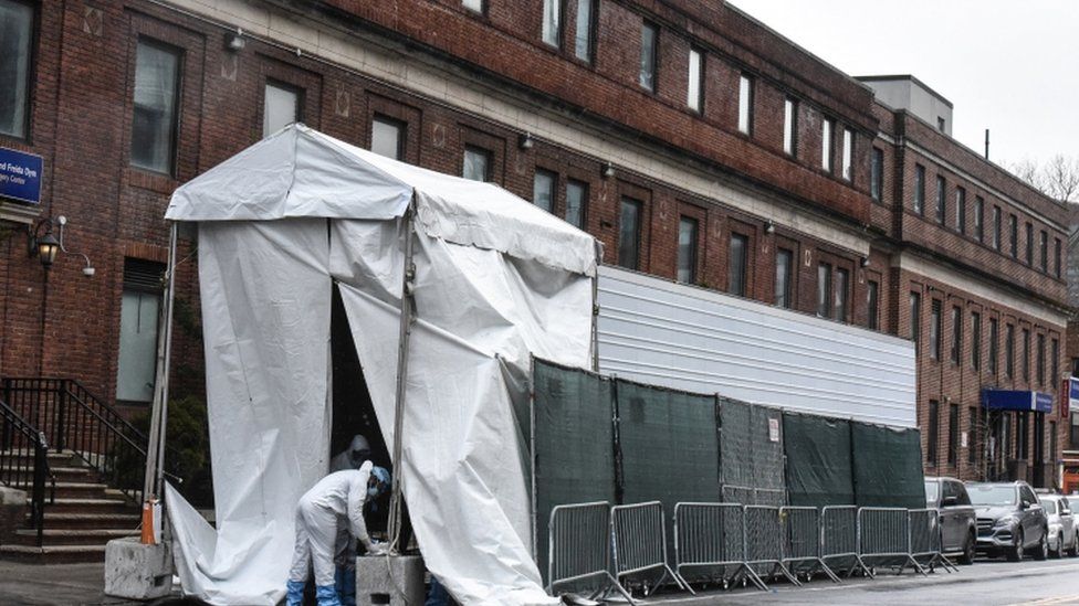 A medical worker approaches a refrigerator truck being used as a morgue outside of Brooklyn Hospital Center amid the coronavirus pandemic on April 3, 2020 in New York City