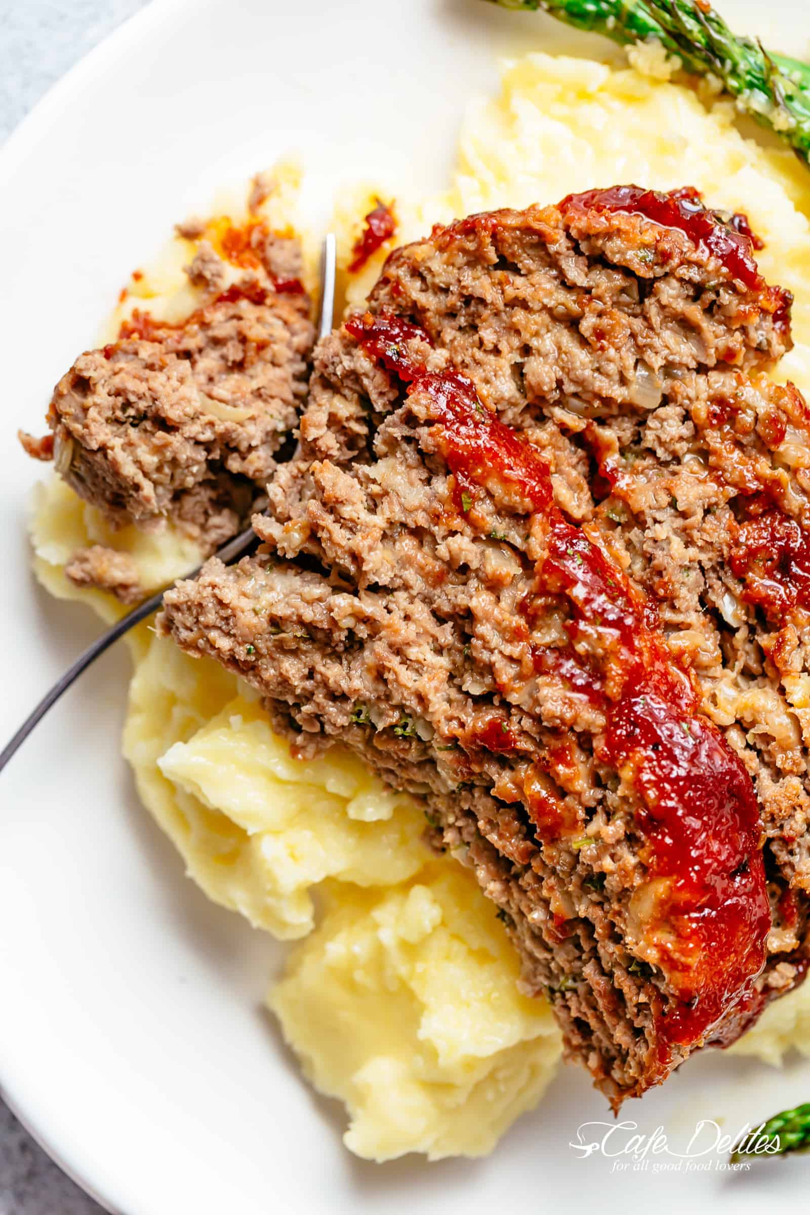 How to make the best tender and juicy Meatloaf with a delicious shiny glaze! Cheap, easy and quick to prepare, let the oven do all the work for you! The whole family goes crazy over each slice of this meatloaf recipe. PLUS... take advantage of leftovers and turn them into the best meatloaf sandwiches! | cafedelites.com