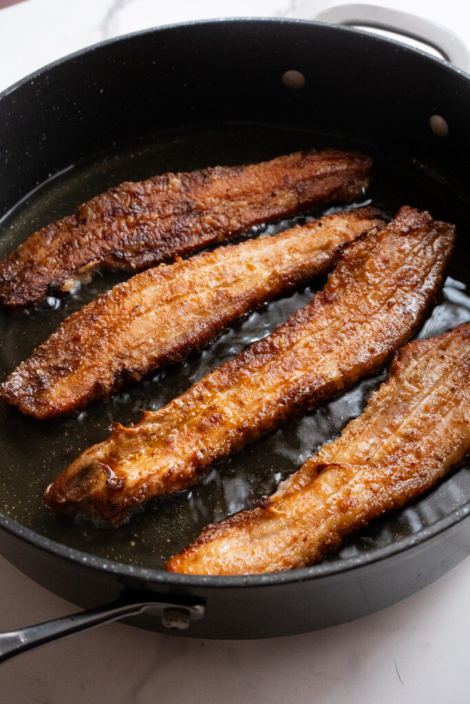 Pork belly frying in hot oil.