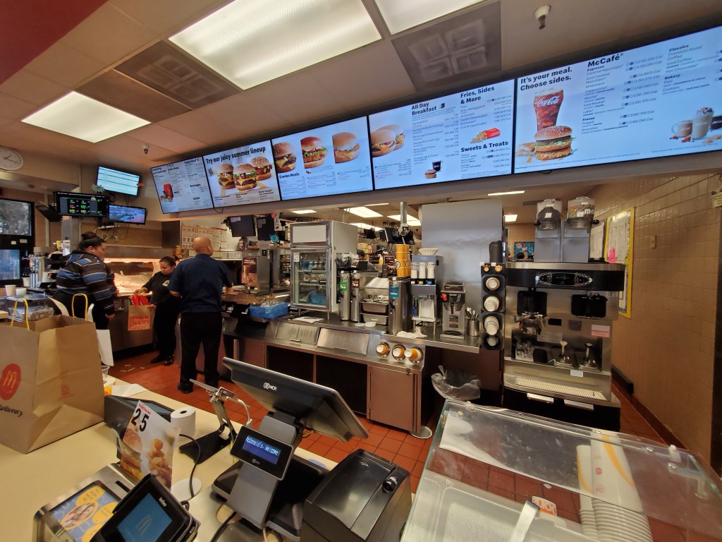Wide angle view of the interior of McDonald's restaurant in San Ramon, California, showing the counter area, kitchen and various menus