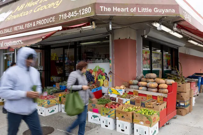 People walk by J&B West Indian & American Grocery