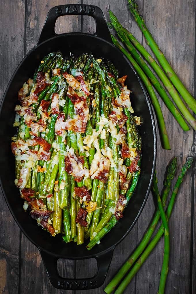 Cheesy Baked Asparagus with Bacon in a cast-iron dish