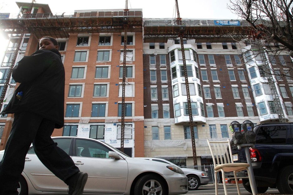 A young man walks past new construction in D.C.'s 7th Street NW corridor.