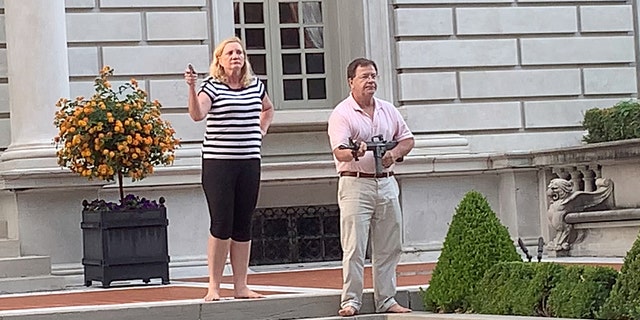 Mark and Patricia McCloskey drawing their firearms on the crowd marching toward St. Louis Mayor Lyda Krewson's home last month. On Monday, St. Louis Circuit Attorney Kim Gardner announced criminal charges against the couple. (DANIEL SHULAR/via REUTERS, File)