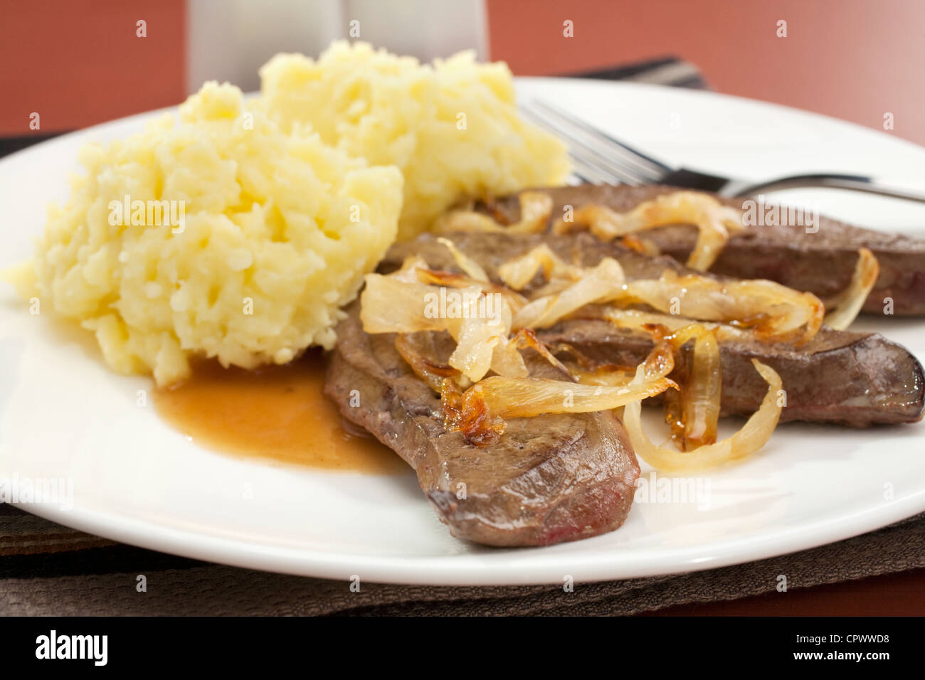 lambs-liver-with-caramelised-onions-and-mashed-potato-on-a-white-plate-CPWWD8.jpg