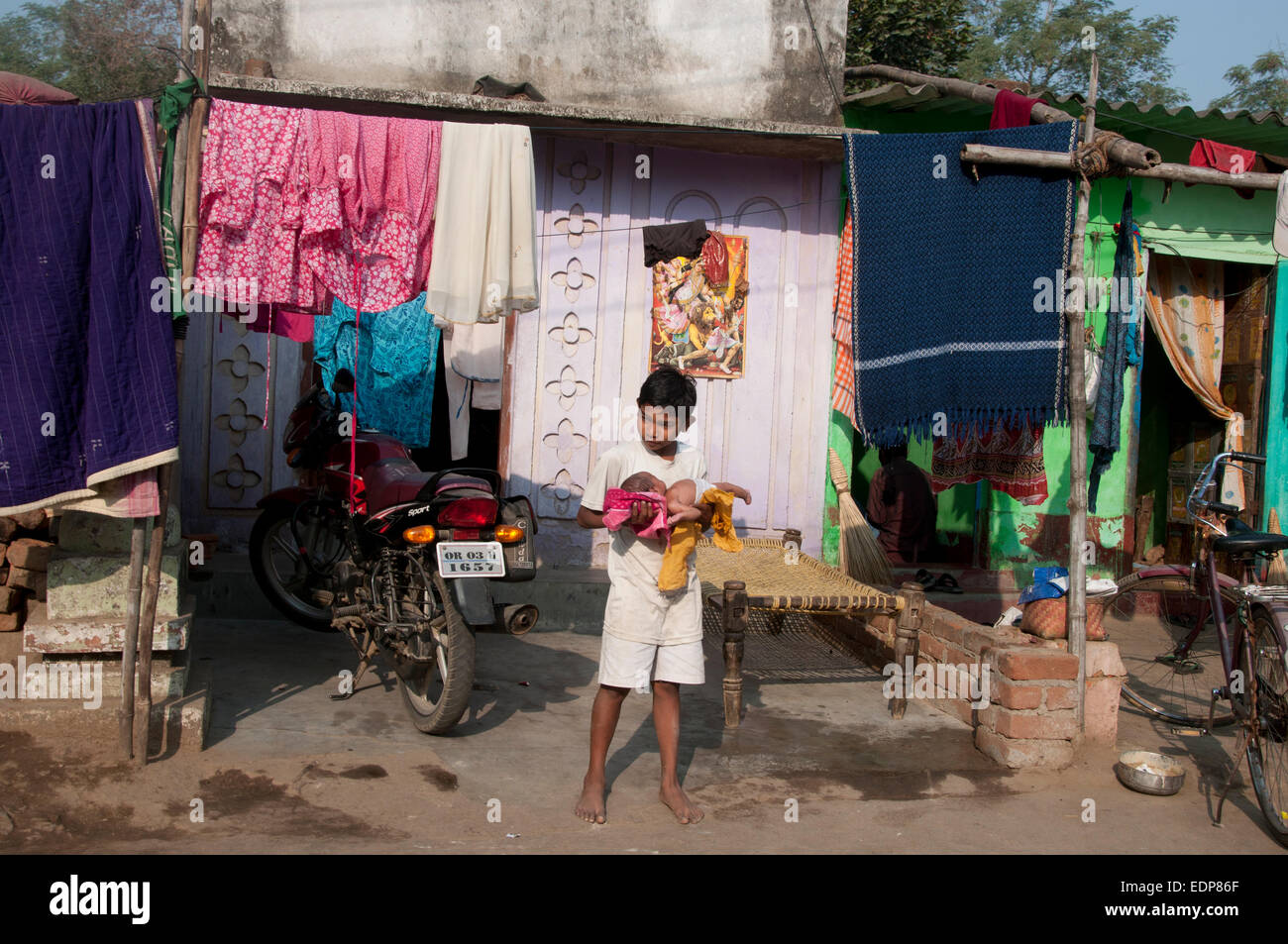 india-2014-orissa-sambalpur-poor-housing-boy-holding-baby-in-front-EDP86F.jpg