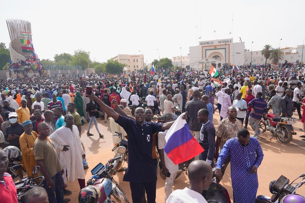 Nigeriens, some holding Russian flags, participate in a march called by supporters of coup leader Gen. Abdourahmane Tchiani in Niamey, Niger.