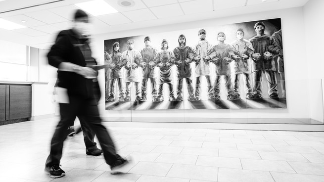 Hospital staff walk by a Frontline Warriors mural at Long Island Jewish Medical Center