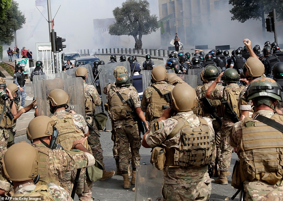 31715354-8607361-Lebanese_security_forces_advance_during_clashes_with_protesters_-a-40_1596900772235.jpg