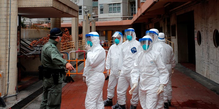 Police in protective gear wait to evacuate residents from a public housing building, following the outbreak of the novel coronavirus, in Hong Kong, China February 11, 2020. REUTERS/Tyrone Siu