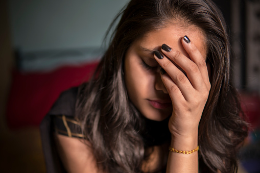 portrait-of-young-girl-holding-her-head-and-feeling-headache-picture-id1277120551