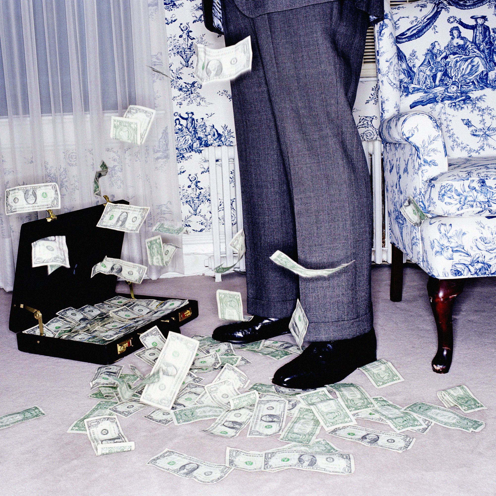 A waist down image of a businessman  with a suitcase of money at his feet. A waist down image of a businessman  with a suitcase of money at his feet.