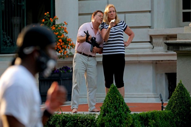 Mark and Patricia McCloskey, standing in front their house along Portland Place confront protesters marching to St. Louis Mayor Lyda Krewson's house in the Central West End of St. Louis.