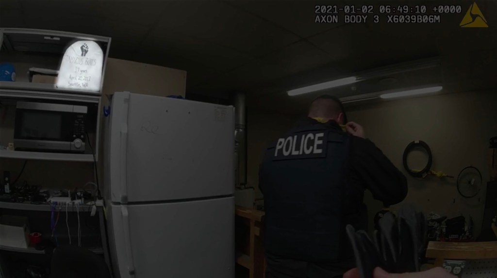 Screengrab showing officer walking near the shelf with Butts' tombstone.