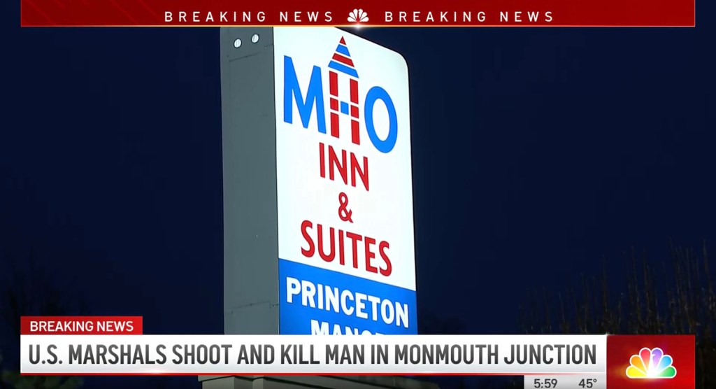 MHO Inn & Suites lit up sign against dark night sky 