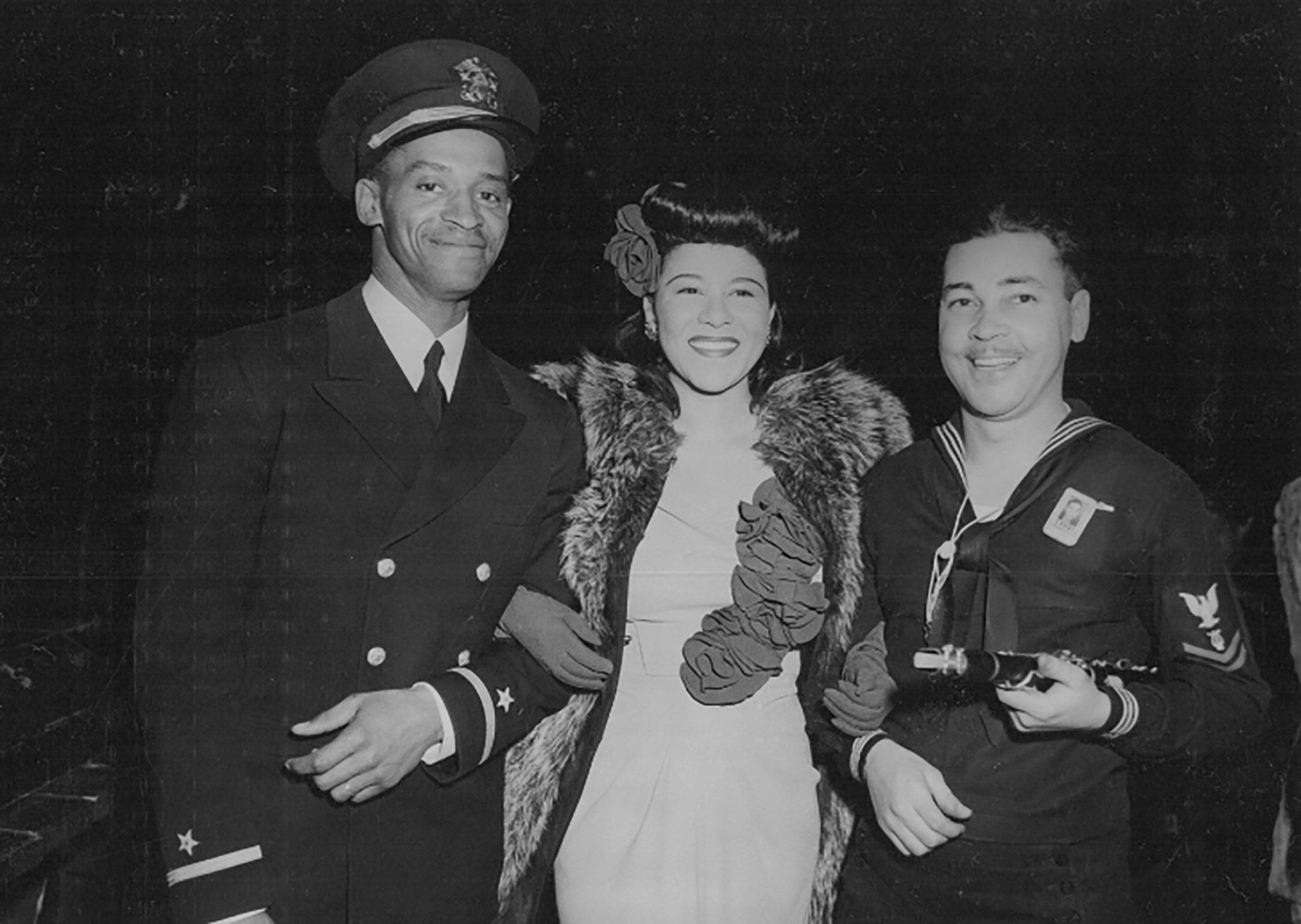 Marva Louis, wife of heavyweight champion Joe Louis, entertained some two thousand black men in April 1944 at the Naval Training Station, Great Lakes. She is shown here with Ensign Sam Barnes and Willie Smith, musician second class, a nationally known saxophone player.