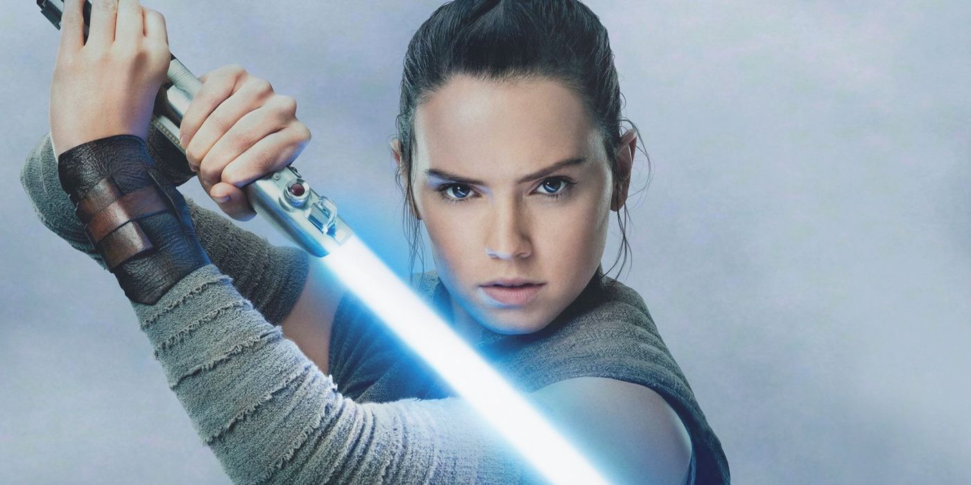 Rey holding her lightsaber in Star Wars.