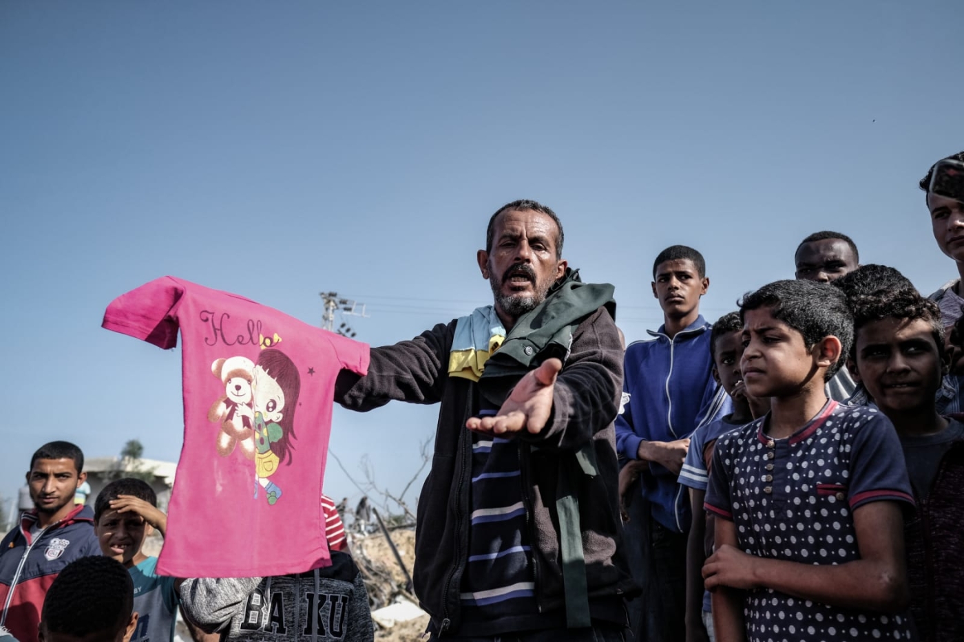 2019-11-14_a_relative_of_sawarka_family_holds_a_pink_t-shirt_at_the_site_bombarded_by_an_israeli_airstrike_meefatima_m._shbair.jpg