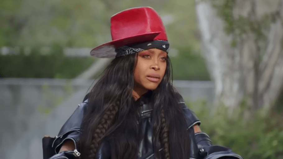 erykah badu in red hat and black outfit